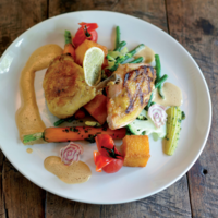 Serveersuggestie gekonfijte en gegrilde kip met jus, groenten in gremolata en krokante polenta