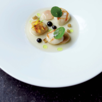 Serveersuggestie Coquille met merg gerookte knolselderijbouillon met macadamianoten en lapsang
